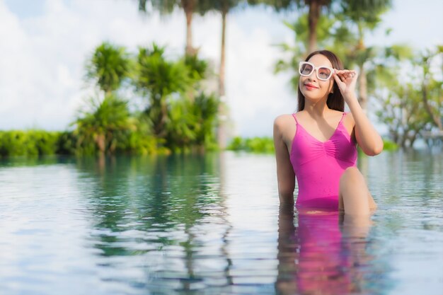 Porträt schöne junge asiatische Frau entspannen genießen um Freibad im Urlaub Urlaub