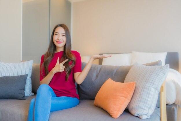 Porträt schöne junge asiatische Frau entspannen Lächeln auf dem Sofa im Wohnbereich