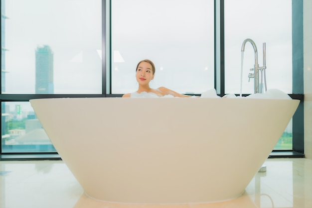 Porträt schöne junge asiatische Frau entspannen Lächeln Freizeit in der Badewanne im Badezimmer Interieur