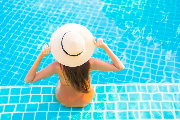 Porträt schöne junge asiatische frau entspannen lächeln freizeit rund um den schwimmbad mit meerblick