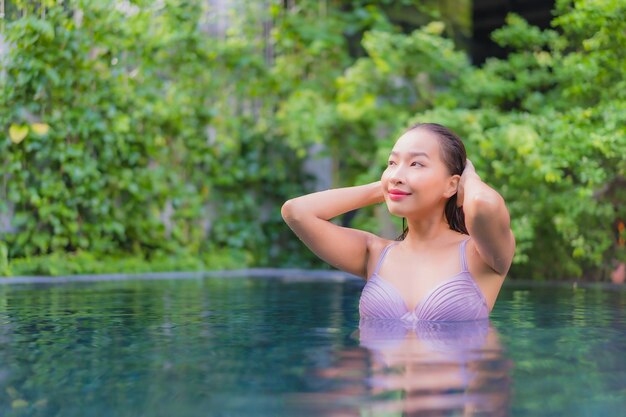 Porträt schöne junge asiatische frau entspannen lächeln freizeit um freibad im hotel resort