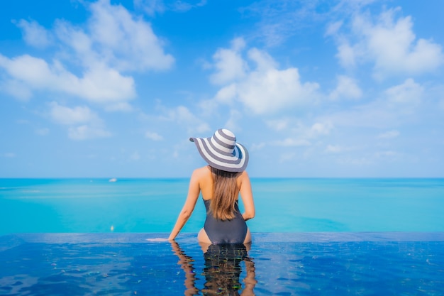 Porträt schöne junge asiatische Frau entspannen Lächeln Freizeit um Freibad im Resort Hotel mit Meerblick