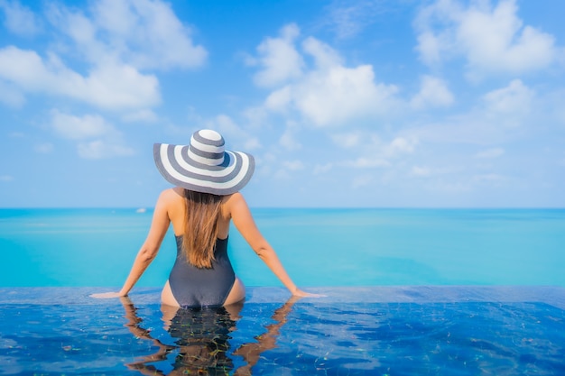 Porträt schöne junge asiatische Frau entspannen Lächeln Freizeit um Freibad im Resort Hotel mit Meerblick