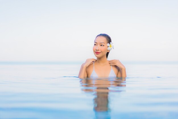 Porträt schöne junge asiatische Frau entspannen Lächeln um Außenpool im Hotel Resort