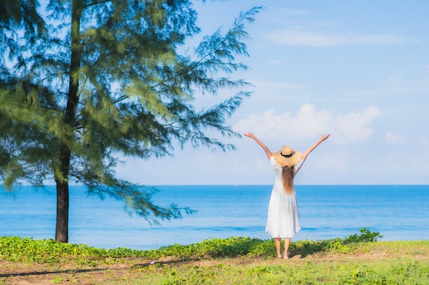 Porträt schöne junge asiatische Frau entspannen Lächeln um Strand Meer Ozean mit weißer Wolke des blauen Himmels für Reiseurlaub