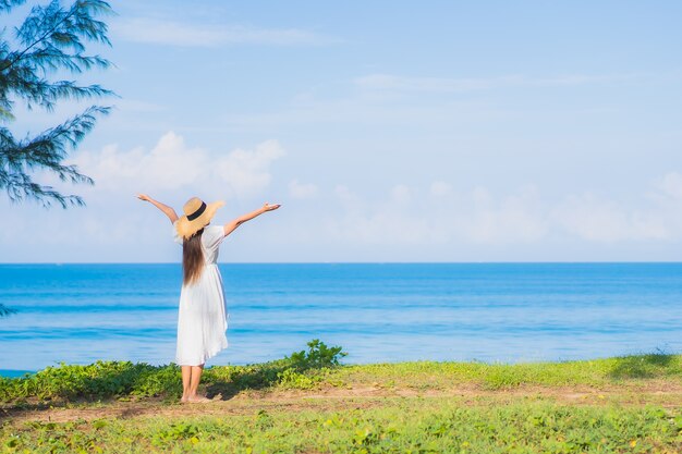 Porträt schöne junge asiatische Frau entspannen Lächeln um Strand Meer Ozean mit weißer Wolke des blauen Himmels für Reiseurlaub