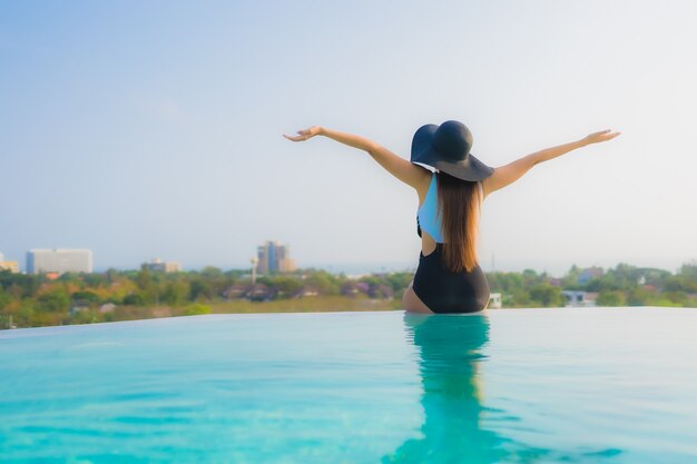 Porträt schöne junge asiatische Frau glückliches Lächeln entspannen um Freibad im Hotel Resort