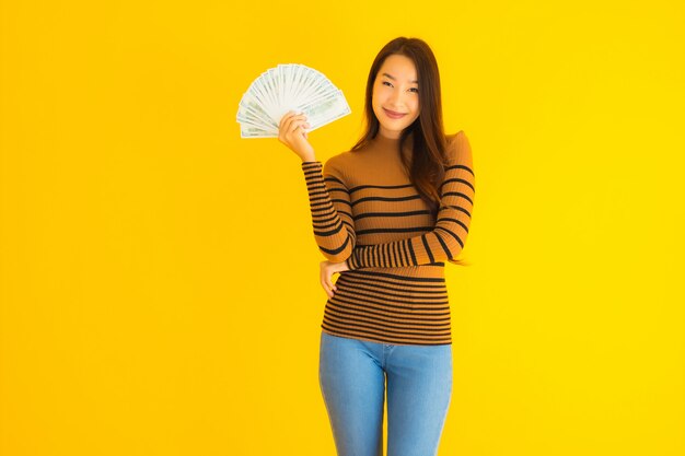 Porträt schöne junge asiatische Frau glückliches Lächeln und reich mit viel Geld in der Hand