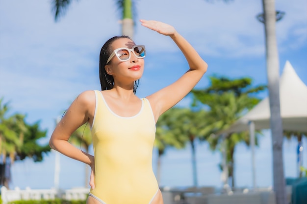 Porträt schöne junge asiatische Frau im Freien im Schwimmbad in Urlaubsreise entspannen