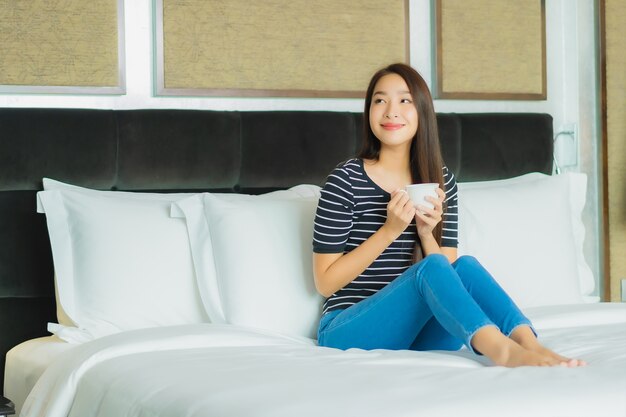 Porträt schöne junge asiatische Frau Lächeln entspannen auf dem Bett im Schlafzimmer Interieur