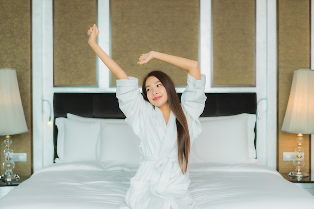 Porträt schöne junge asiatische Frau Lächeln entspannen auf dem Bett im Schlafzimmer Interieur