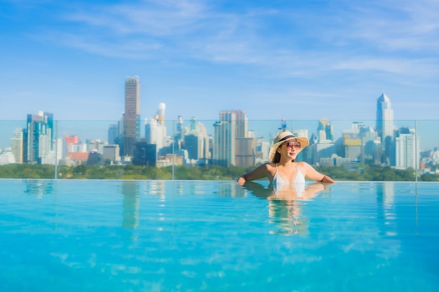 Porträt schöne junge asiatische Frau Lächeln entspannen Freizeit um Freibad mit Blick auf die Stadt