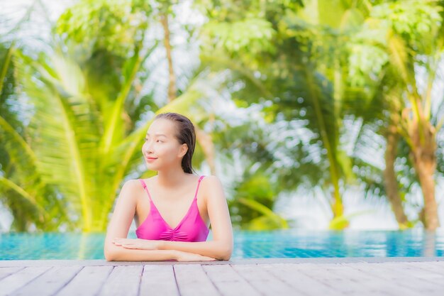 Porträt schöne junge asiatische Frau Lächeln entspannen um Außenpool im Resort Hotel auf Urlaub Urlaub Reise Reise