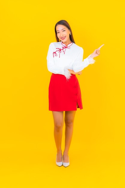 Porträt schöne junge asiatische Frau Lächeln in Aktion auf Gelb