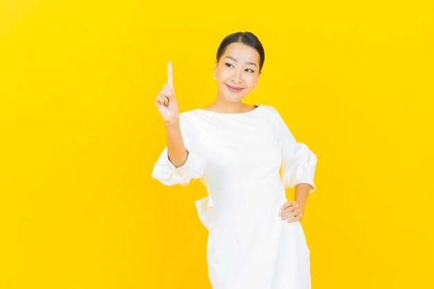 Porträt schöne junge asiatische Frau Lächeln mit Aktion auf Gelb with