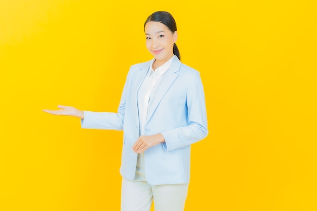 Porträt schöne junge asiatische Frau Lächeln mit Aktion auf Gelb