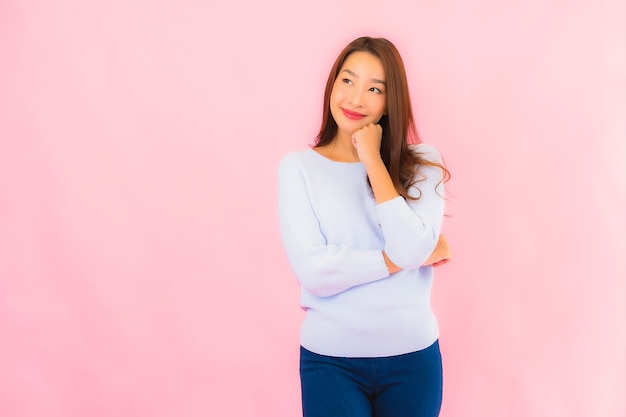 Porträt schöne junge asiatische Frau lächeln mit Aktion auf rosa isolierte Wand