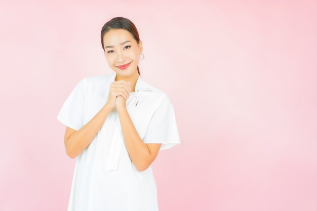 Porträt schöne junge asiatische Frau lächeln mit vielen Aktion auf rosa Wand