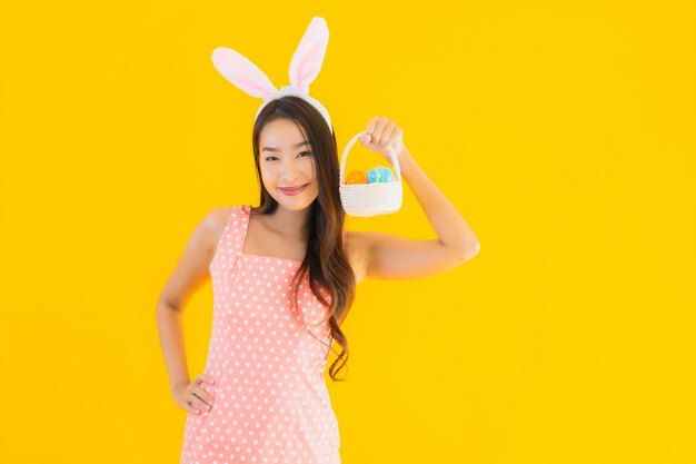 Porträt schöne junge asiatische Frau mit Hasenohren mit Ostereiern
