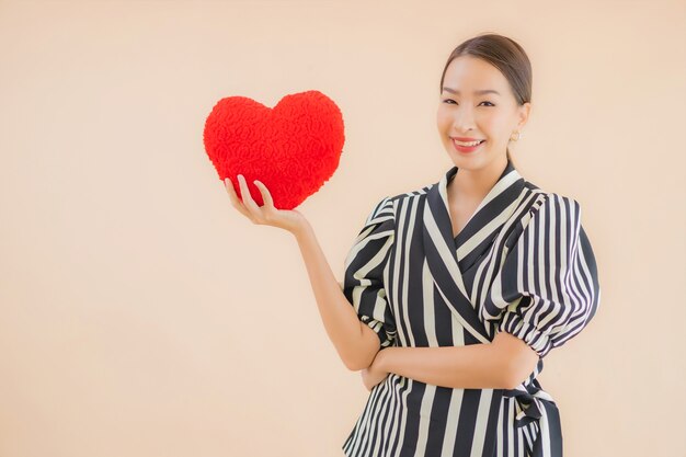 Porträt schöne junge asiatische Frau mit Herzkissen