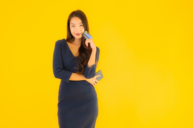 Porträt schöne junge asiatische Frau mit Telefon und Kreditkarte