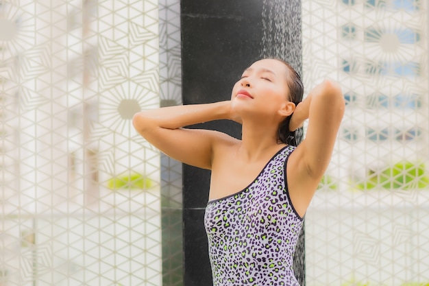 Porträt schöne junge asiatische frau nehmen eine dusche um außenpool