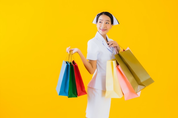 Porträt schöne junge asiatische Frau thailändische Krankenschwester mit Einkaufstasche und Kreditkarte
