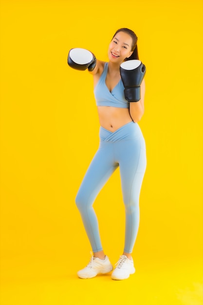 Porträt schöne junge asiatische Frau tragen Sportbekleidung auf gelb
