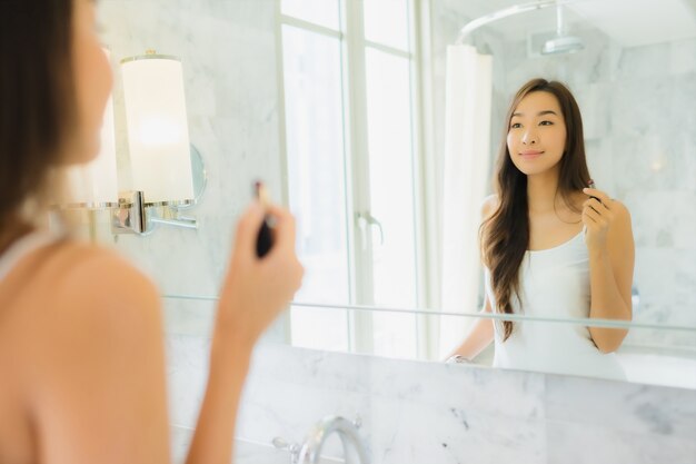 Porträt schöne junge asiatische Frau überprüft und macht ihr Gesicht