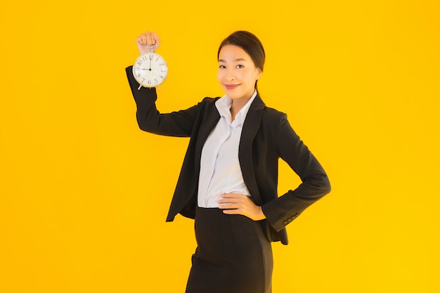 Porträt schöne junge asiatische Frau zeigen Uhr oder Alarm