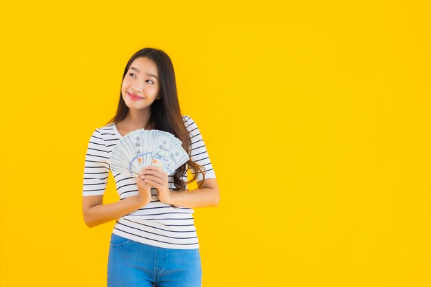 Porträt schöne junge asiatische Frau zeigen viel Dollar Bargeld oder Geld