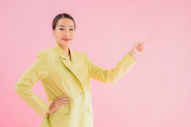 Porträt schöne junge asiatische Geschäftsfrau lächeln in Aktion auf rosa Farbe