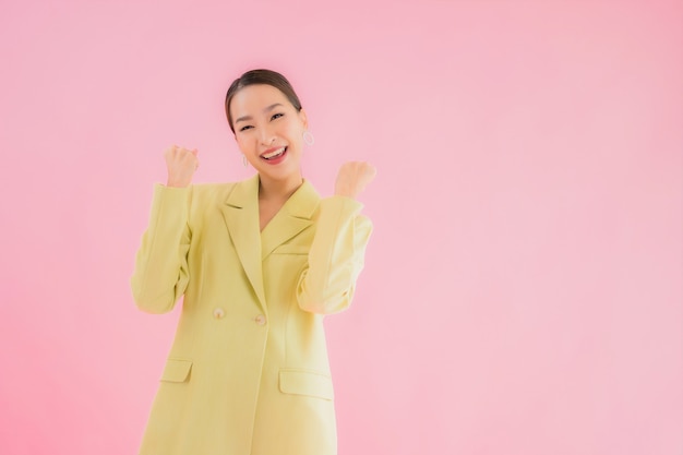 Porträt schöne junge asiatische Geschäftsfrau lächeln in Aktion auf rosa Farbe