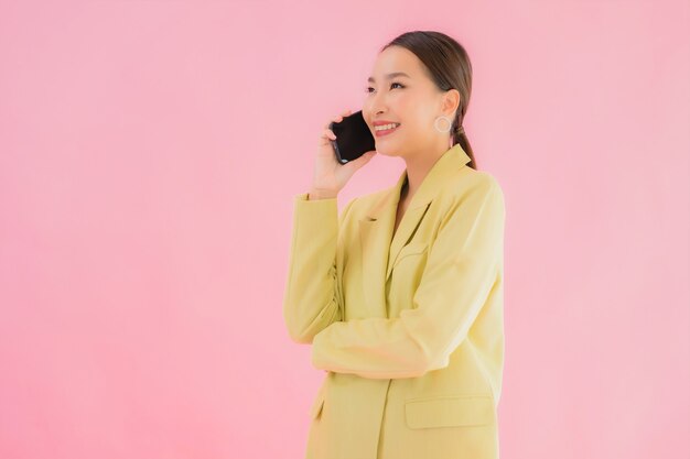 Porträt schöne junge asiatische Geschäftsfrau verwenden intelligentes Mobiltelefon mit Kaffeetasse auf Farbe