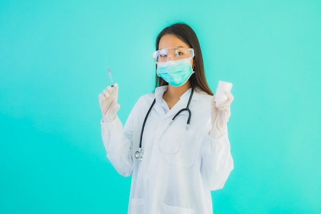 Porträt schöne junge asiatische Ärztin mit Impfstoffspritze und Drung oder Medizinflasche