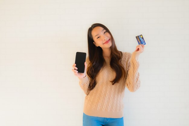 Porträt schöne junge asiatische verwenden mobiles Smartphone mit Kreditkarte