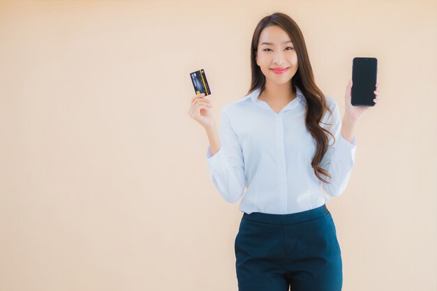 Porträt schöne junge Geschäftsasiatin mit Telefon und Kreditkarte