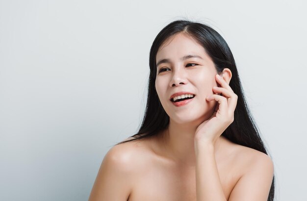 Porträt von attraktiven asiatischen Schönheitsfrauen in der Schönheitsmode, die mit lächelndem Gesicht auf weißem Hintergrund für Kosmetik oder Körperpflege aufwirft