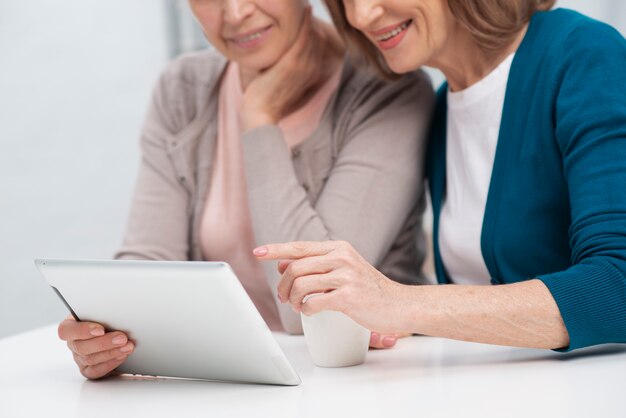 Porträt von den Frauen, die auf einer Tablette grasen