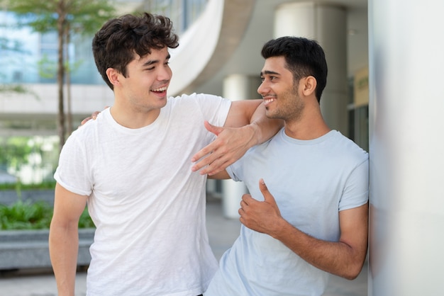 Porträt von den glücklichen multiethnischen männlichen sprechenden und lachenden Freunden