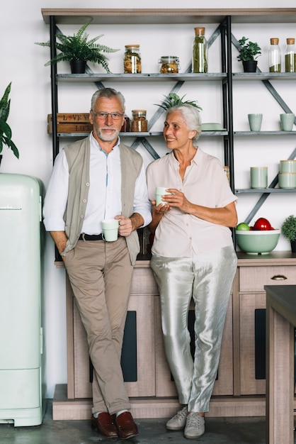 Porträt von den jungen Paaren, die Tasse Kaffee in den Händen halten