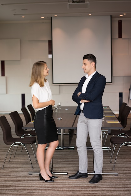 Porträt von den positiven Geschäftskollegen, die im Sitzungssaal sprechen.