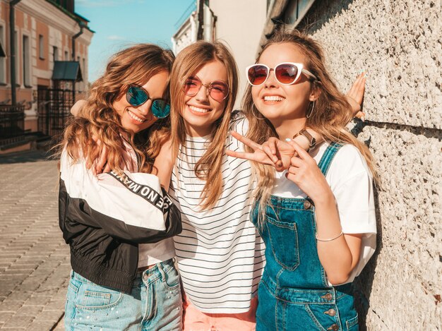 Porträt von den sexy sorglosen Frauen, die auf dem Straßenhintergrund aufwerfen Positive Modelle, die Spaß in der Sonnenbrille haben umarmen