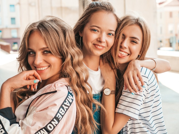 Kostenloses Foto porträt von drei jungen schönen lächelnden hippie-mädchen in der modischen sommerkleidung. sexy sorglose frauen, die auf der straße aufwerfen positive modelle, die spaß haben umarmen