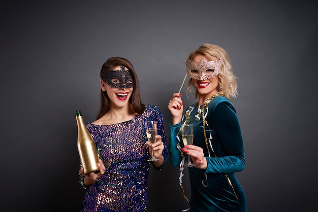 Porträt von Frauen in Masken, die Champagner trinken