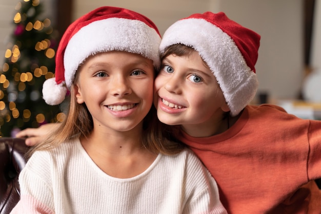 Kostenloses Foto porträt von geschwistern, die zusammen weihnachten feiern