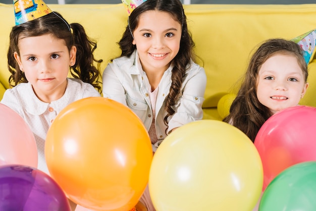 Kostenloses Foto porträt von glücklichen mädchen mit bunten ballonen