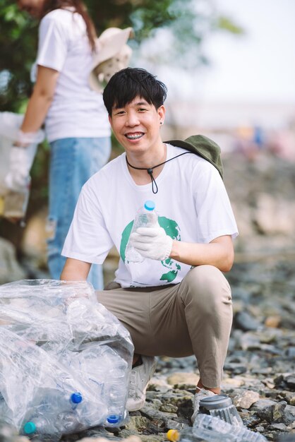 Porträt von jungen erwachsenen asiatischen Menschen, die sich freiwillig für die Teamarbeit im Umweltschutz engagieren Freiwillige helfen beim Sammeln von Plastik- und Schaummüll auf dem Parkgelände