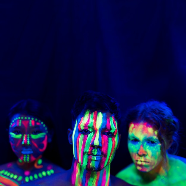 Porträt von Leuten mit UVfarbenmake-up und Kopienraum