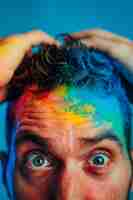 Kostenloses Foto porträt von menschen mit farbenfrohen regenbogen aus ihren gedanken und gehirn auf blauem hintergrund